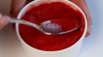 scooping strawberry sorbet with a spoon