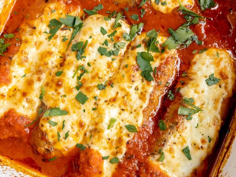 four baked sausages stuffed with cheese and topped with parsley