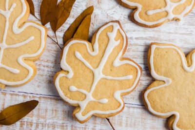 decorated leaf cookies on a table with dried leaves around