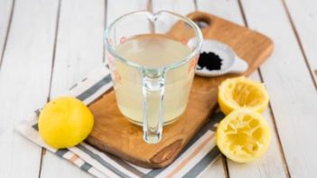 fresh squeezed lemon juice in a pyrex measuring cup with lemons near