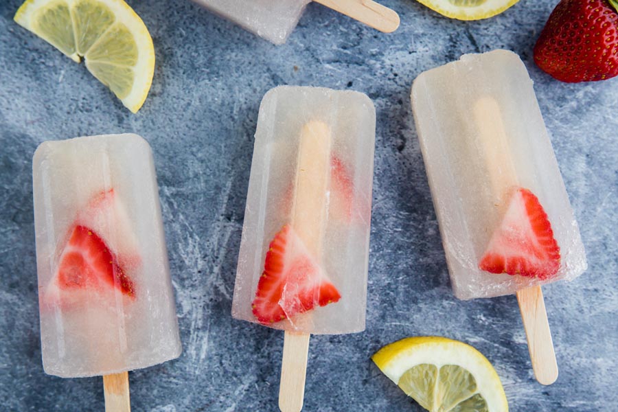 three frozen keto popsicles next to each other on a blue background