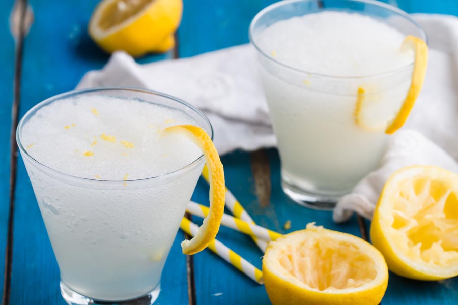 lemonade cocktails with juiced lemons nearby