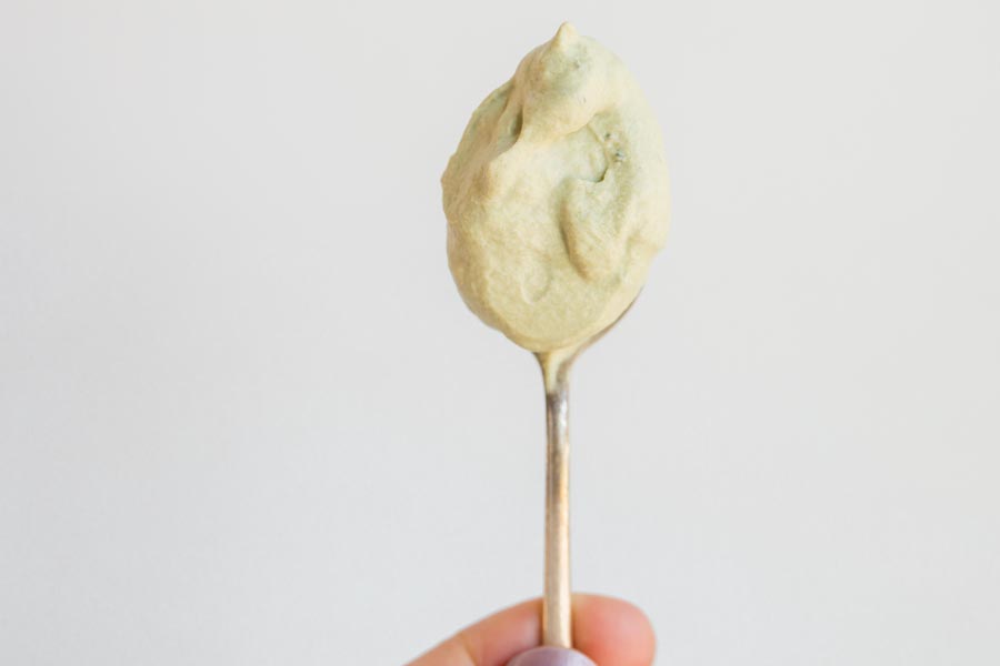 holding a spoon with matcha whipped cream on it