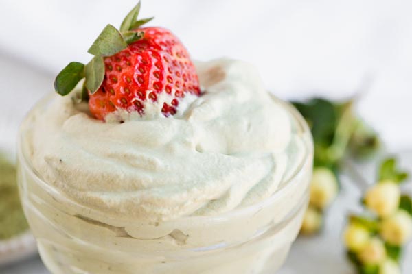 a strawberry on top a bowl of green tea whipped cream