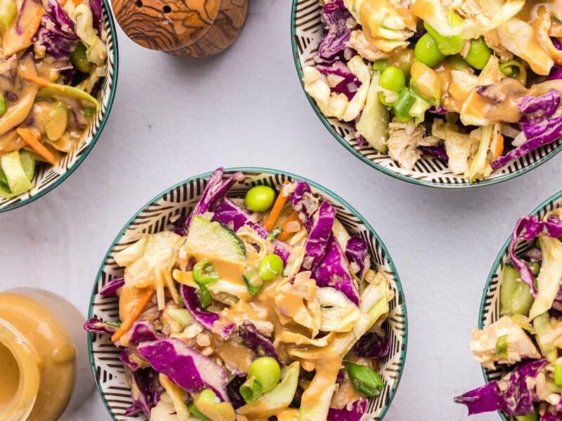 Multiple bowls of crunchy Thai salad with edamame and purple cabbage.