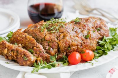 meatloaf plated with whole tomatoes next to it