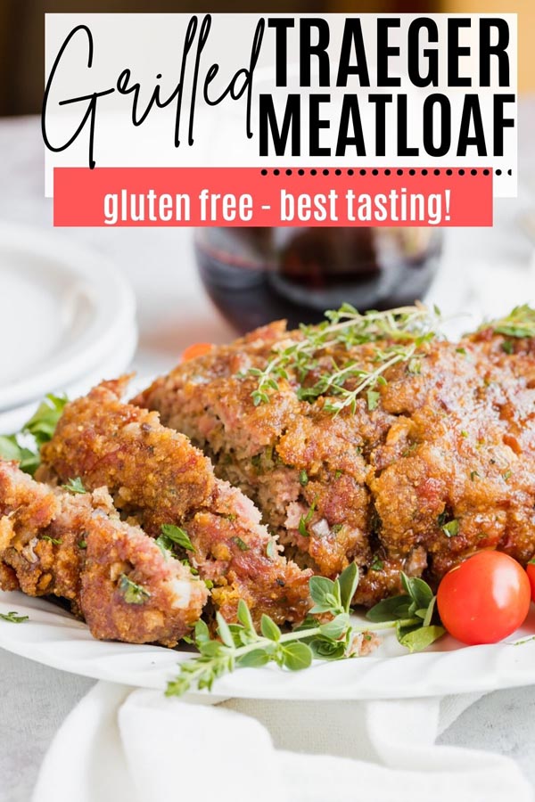 cooked meatloaf on a platter with fresh herbs