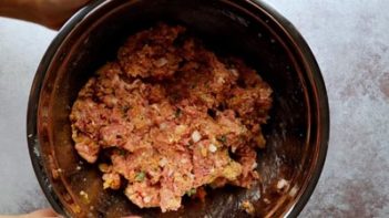 a mixture of meatloaf in a metal bowl