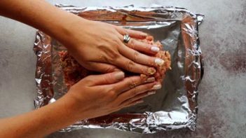 molding a meatloaf into a loaf by hand