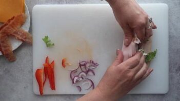 Rolling a turkey wrap with two hands.