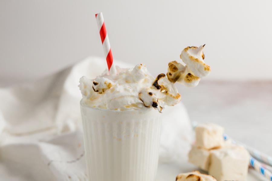 frothy shake with roasted marshmallows stuck in and a straw